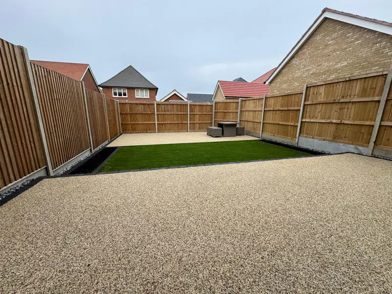 Large resin bound patio across the width of a fenced garden
