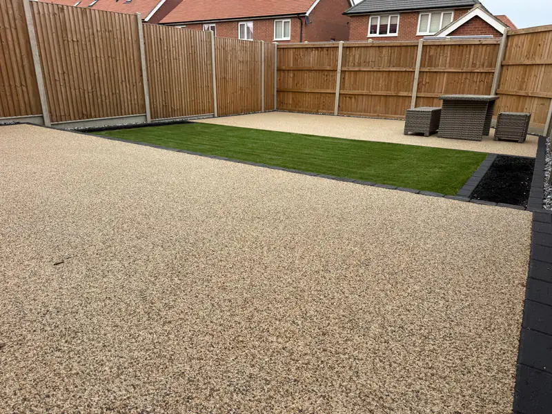Resin bound patio with a lawn and a seating area at the back of the garden