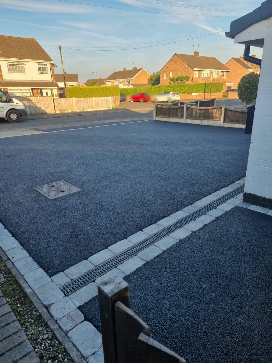 Finished tarmac drive with a channel drain set between rows of block edging