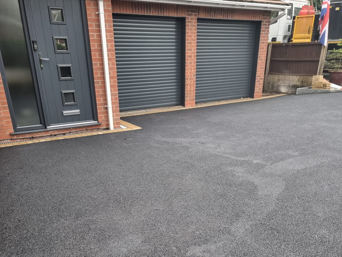 Finished tarmac driveway in front of a house with a double garage