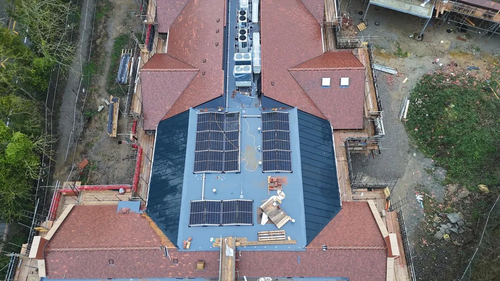 Care home flat roof solar panels — close-up drone, Manchester
