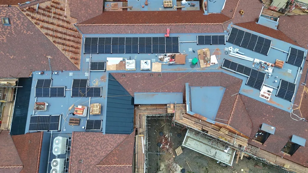 Care home solar panels on pitched and flat roof — aerial, Manchester