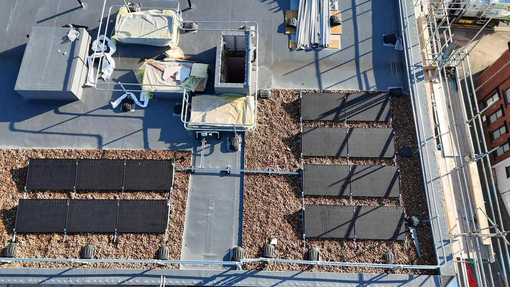Commercial solar panels on ballasted flat roof — close-up, Manchester