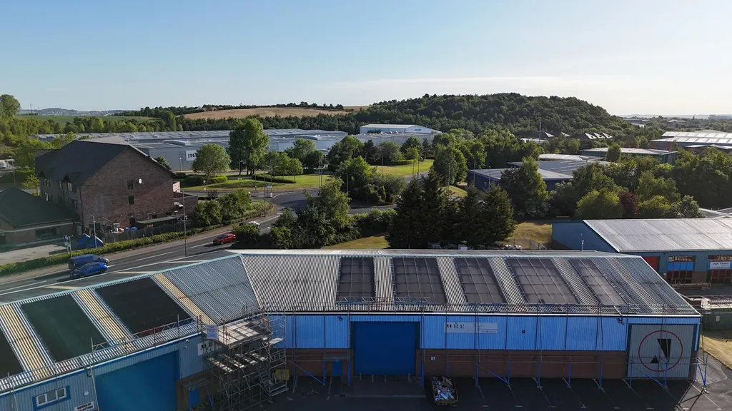 Commercial solar panels on warehouse rooftop — wide angle, Manchester