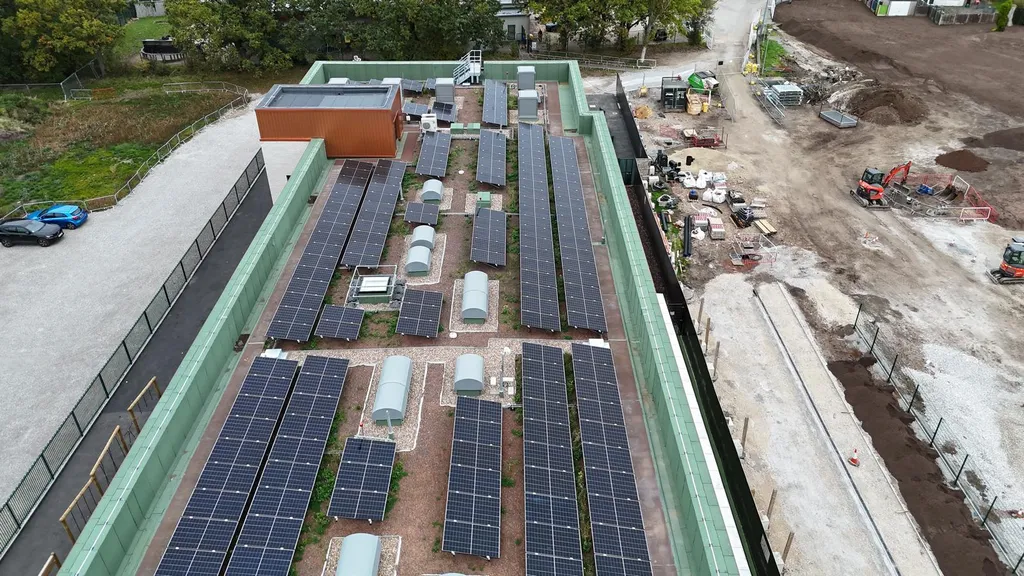 Commercial solar panels on school flat roof — drone, Manchester