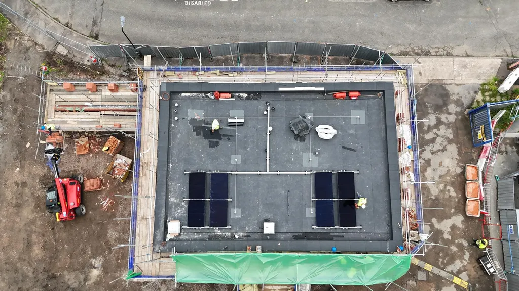 Flat roof solar panels overhead view on commercial building, Manchester