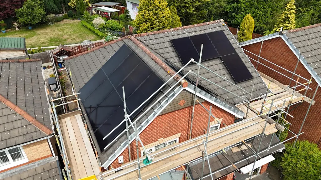 Home solar panels on detached house in Manchester — drone aerial view by Manchester Renewables