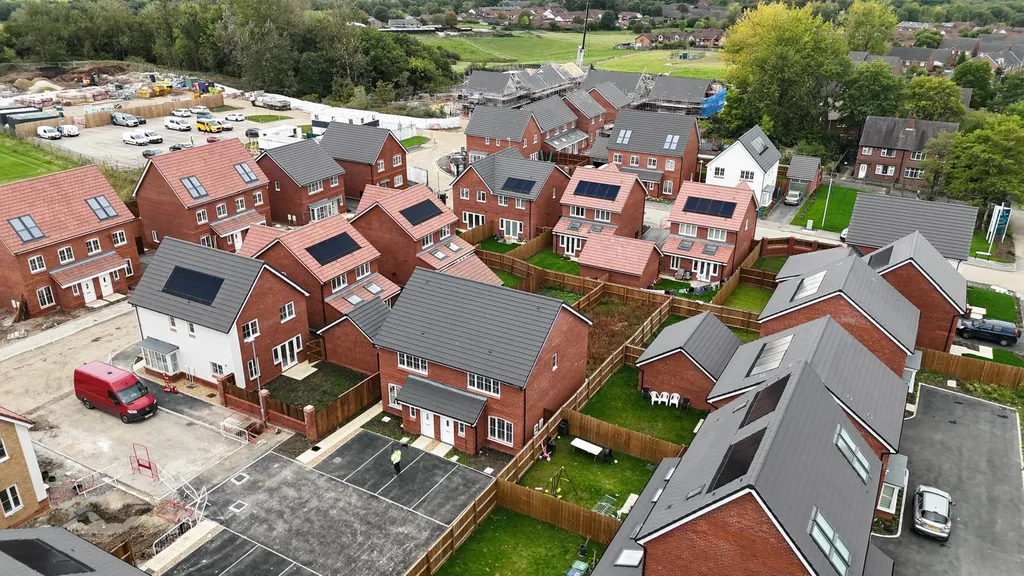New-build estate solar panels — large development aerial, Manchester