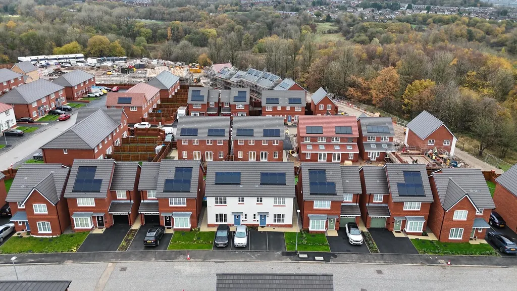 New-build townhouses with in-roof solar panels — drone, Manchester