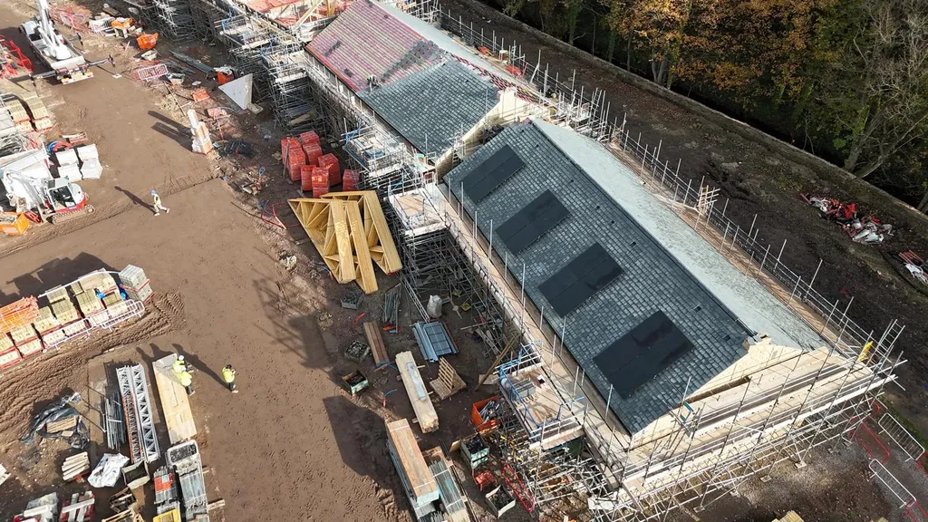 Solar panels on new-build apartment — slate roof drone, Manchester