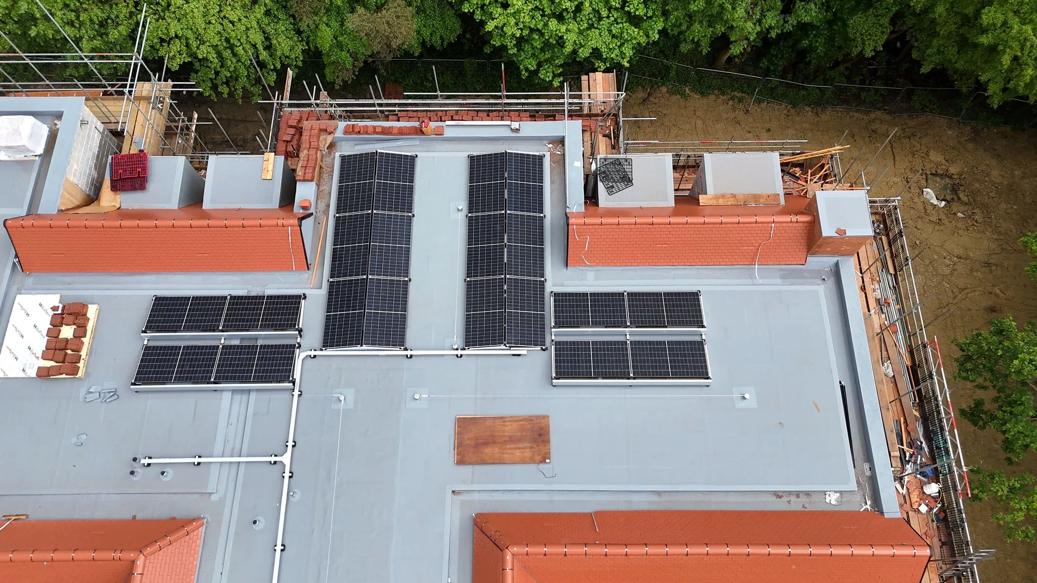 Top-down close-up of the central flat-roof section at the Haywards Heath care home, showing the layout of the commercial solar panel banks across the membrane roof.
