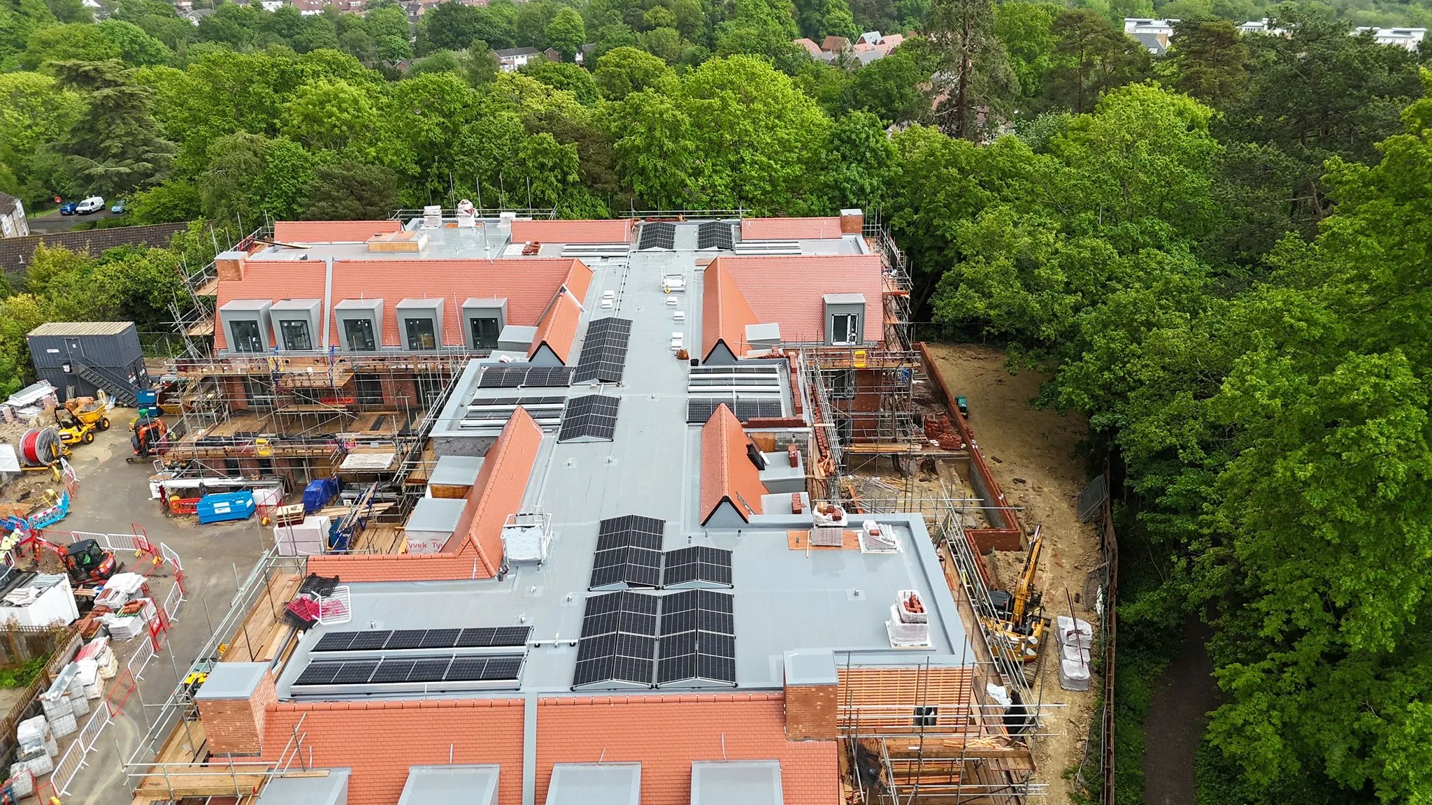 Wide oblique aerial of the full Haywards Heath care home footprint, showing the commercial solar PV rooftop system spread across the central flat-roof sections of the build.