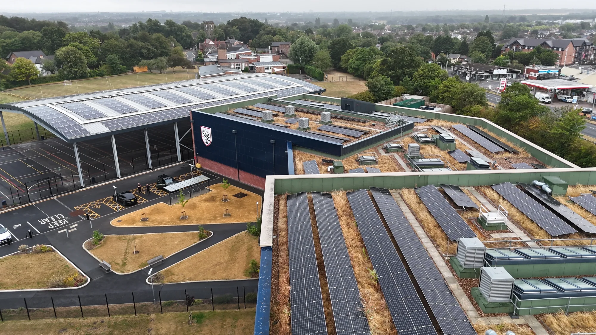 Drone view of Deyes High School, Liverpool showing the solar canopy and rooftop solar panels across the green roofs