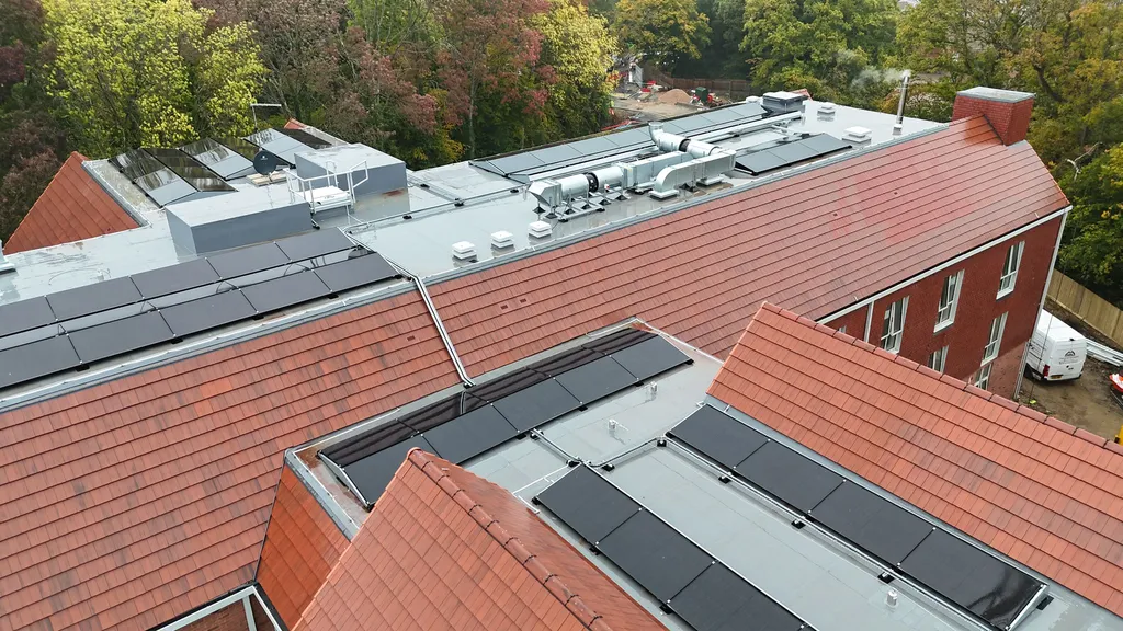 Solar panels on care home complex roof — overhead drone view by Manchester Renewables