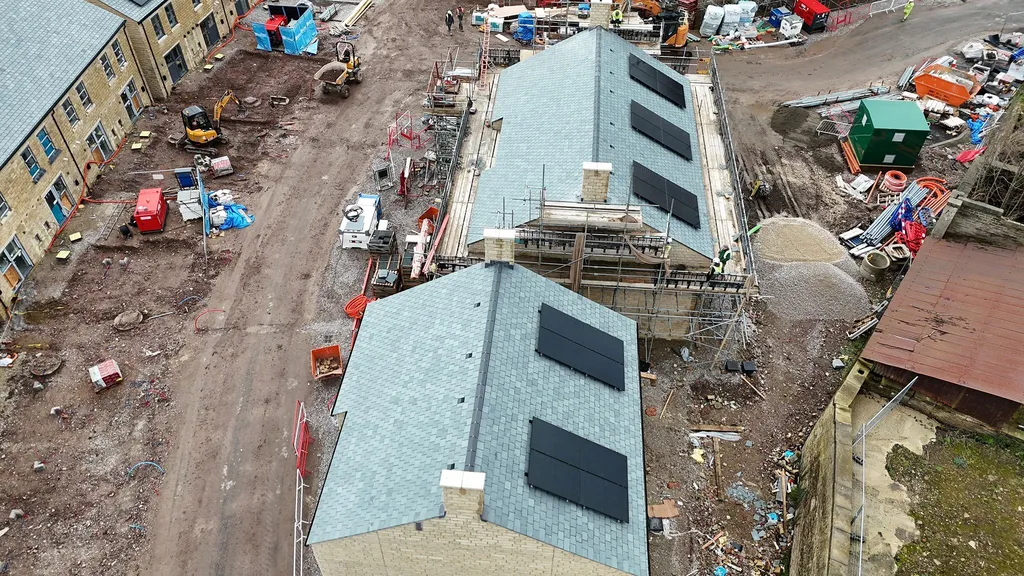 New-build estate in Glossop with solar panels fitted during construction — drone shot