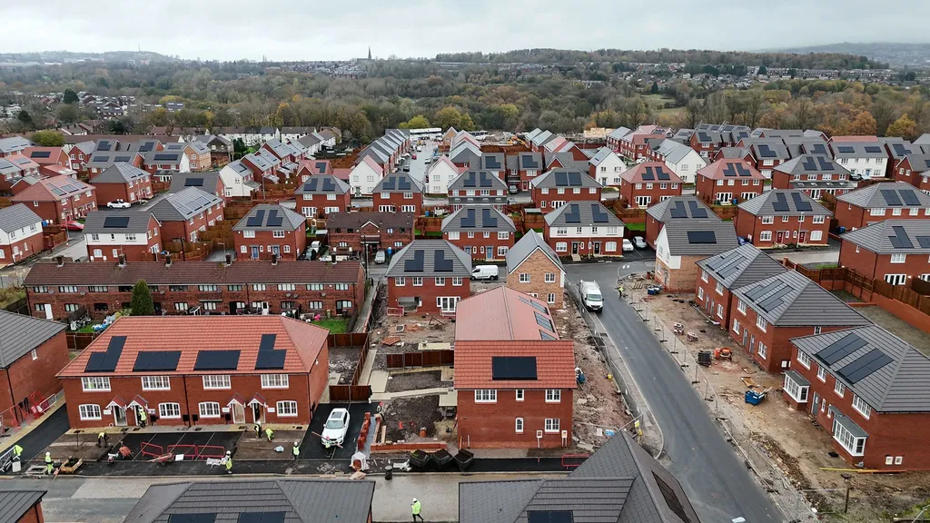 New-build estate in Oldham with solar panels fitted during construction — wide drone view