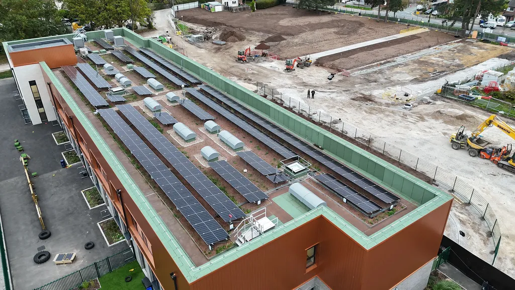 Commercial solar PV on primary school roof — overhead view of panels across multiple sections