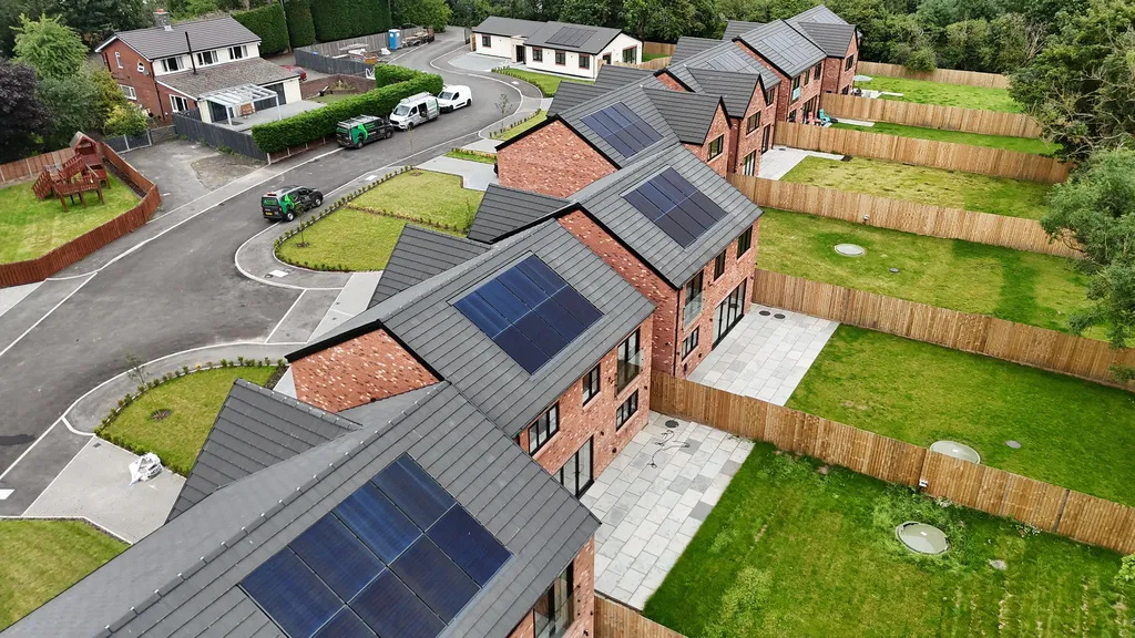 New-build homes with solar panels fitted during construction — drone shot of development