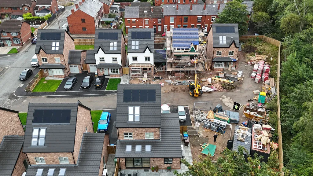 Completed small new-build with solar panels — aerial view of finished properties