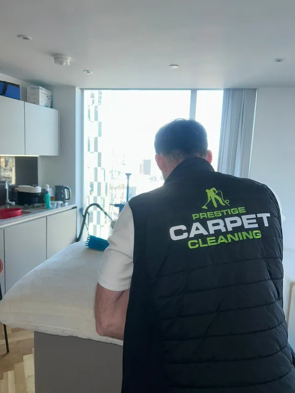 Prestige technician cleaning upholstery in high-rise apartment