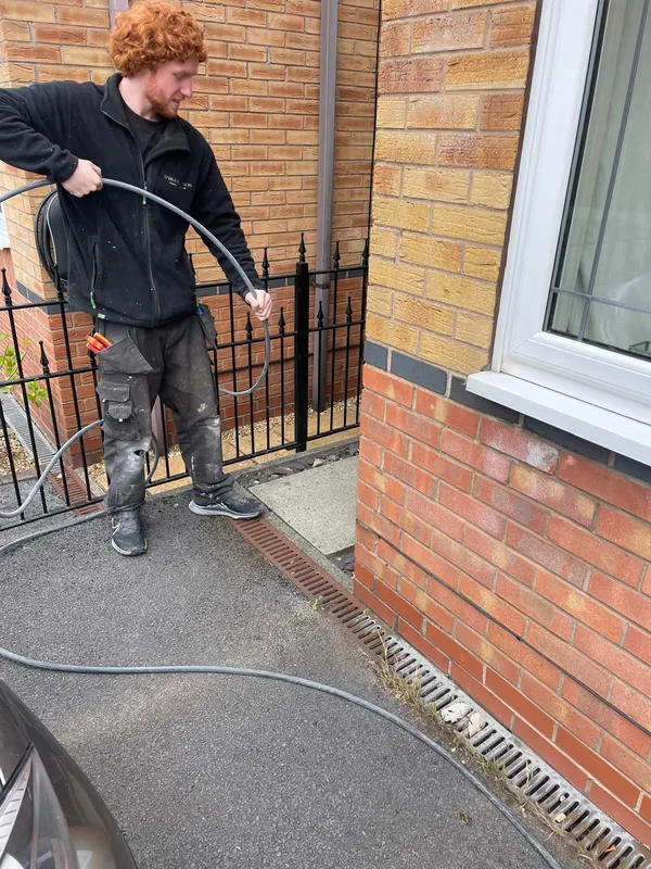 Steels Electrical engineer routing 6mm SWA cable to the EV charger location in Stalybridge