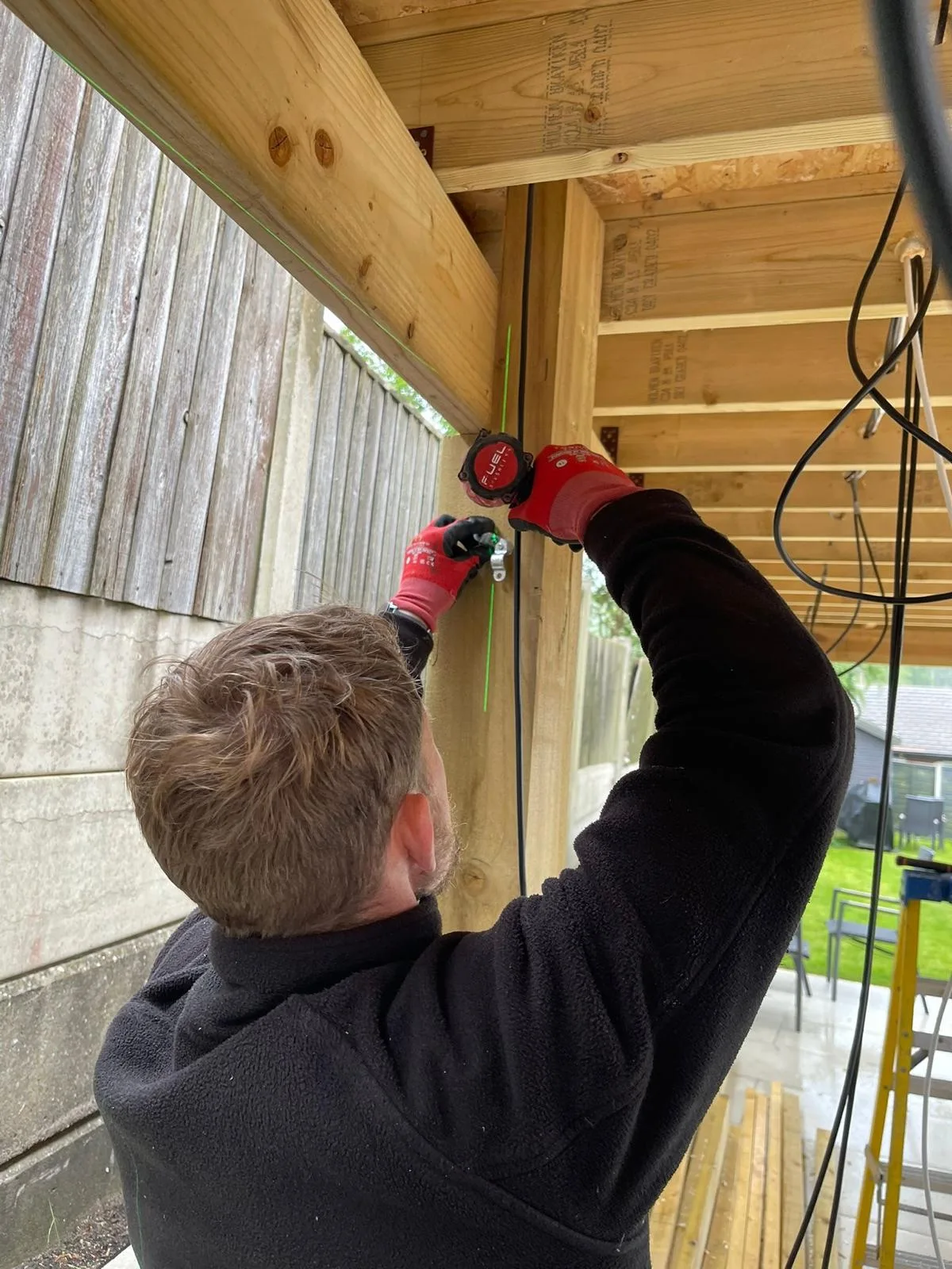 Power and data cabling run down the timber frame of a new garden room in Hyde