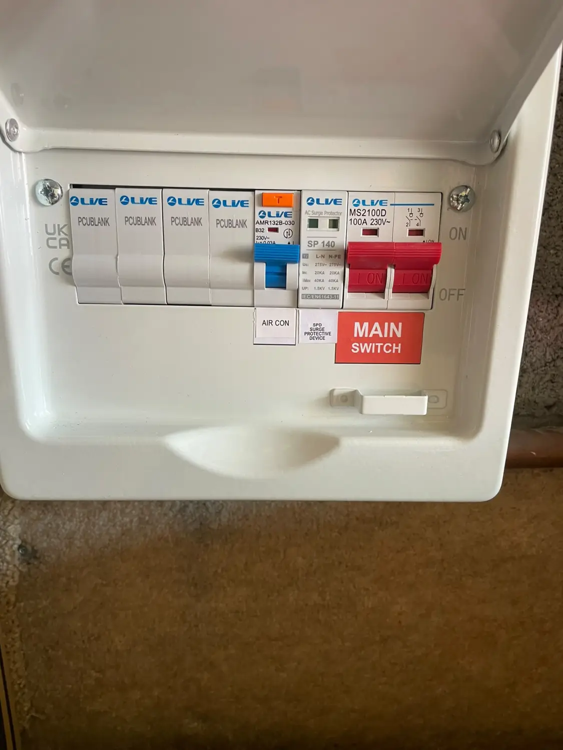 Garage sub-board with a dedicated RCBO labelled Air Con and a surge protection device, feeding the new air conditioning supply in Glossop