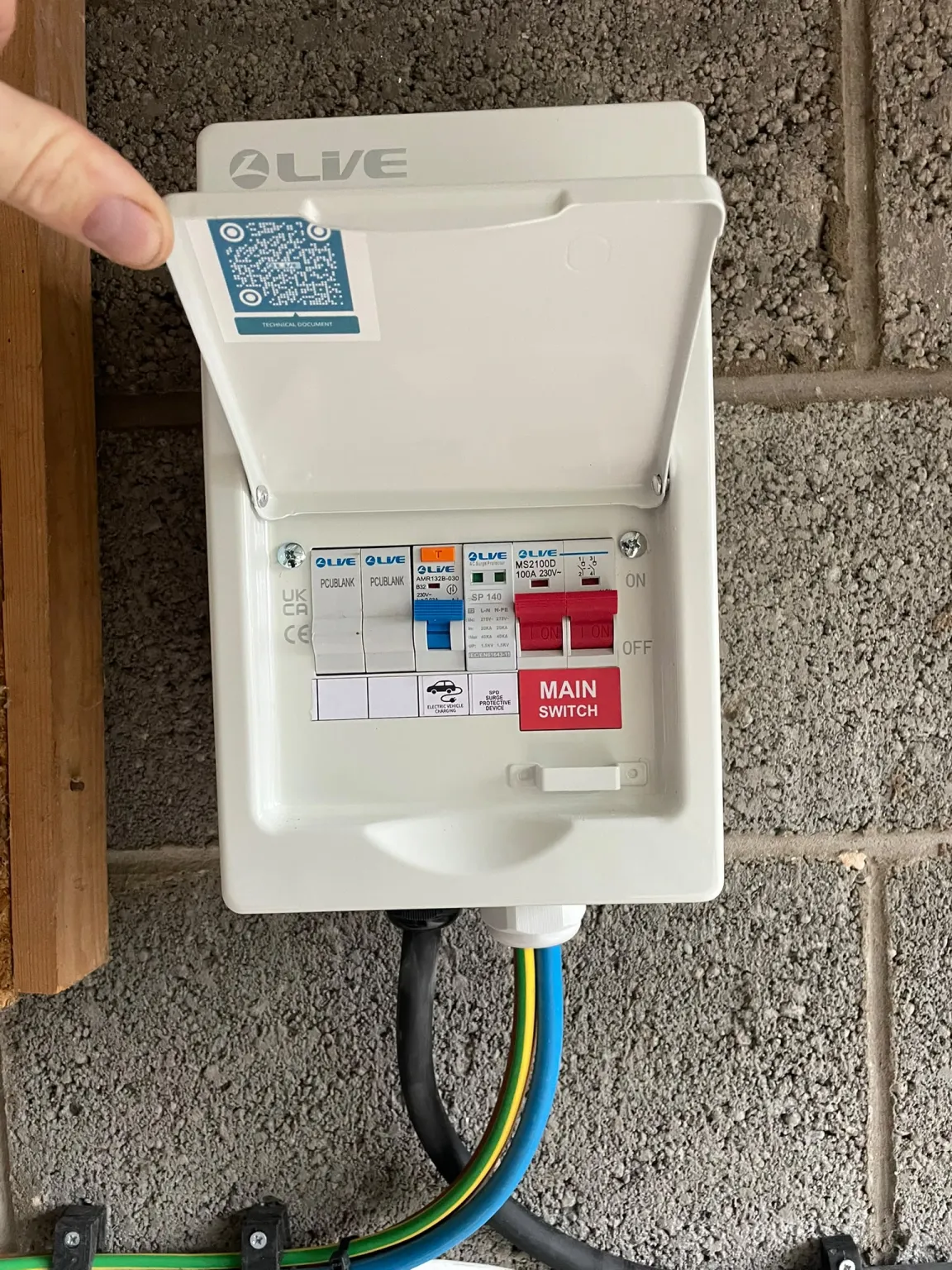 Inside the new EV charger consumer unit in Marple: 32A breaker labelled electric vehicle charging, surge protective device and 100A main switch